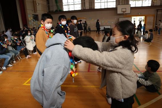 千代田小学校 6年生に首飾りを渡している様子
