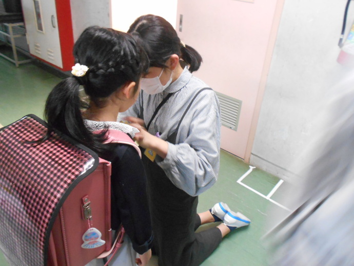 領内小学校 6年生にコサージュをつけてもらう新入生の写真