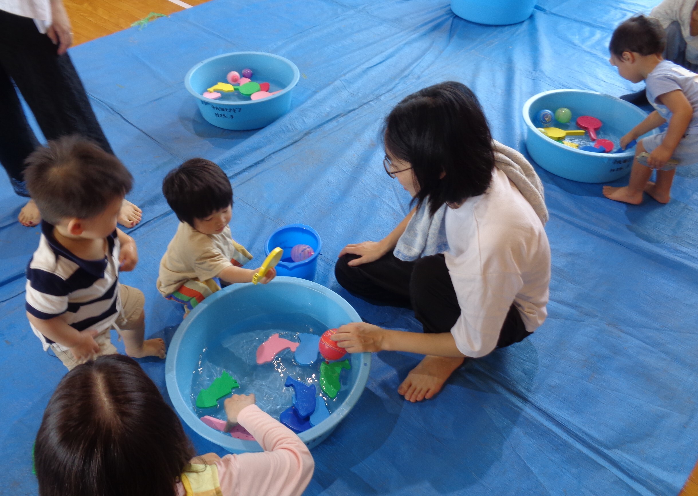 たくさんの親子が一緒にお絵かきをしている様子の写真