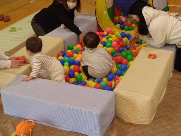 たくさんの親子が部屋いっぱいに広がってストレッチをしている様子の写真